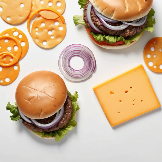 A white background with sliced onions, cheddar cheese, and burger patties scattered around the edges.